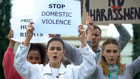 Crowd-chanting-slogans-on-domestic-violence-rally-waving-banners-for-human-right