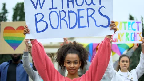 Mujer-sosteniendo-el-cartel-del-amor-sin-fronteras-junto-con-activistas-LGBT,-orgullo