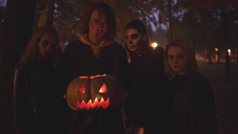 Four-caucasian-friends-celebrating-all-saints-night.-Group-of-young-people-with-a-scary-Halloween-make-up-in-the-night-park