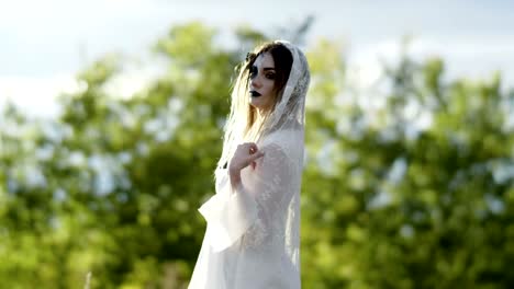 The-young-woman-with-spooky-make-up-for-Halloween-in-a-white-bride-dress.-4K