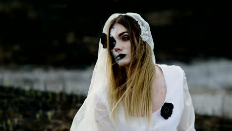 The-young-woman-with-spooky-make-up-for-Halloween-in-a-white-bride-dress.-4K