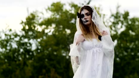 La-joven-con-maquillaje-espeluznante-para-Halloween-en-un-vestido-de-novia-blanco.-4K