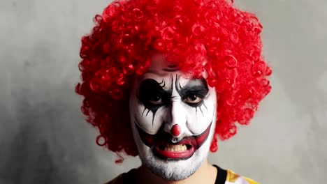 Porträt-von-beängstigend-wütend-Enman-Clown-mit-Halloween-Make-up-und-rote-lockige-Perücke