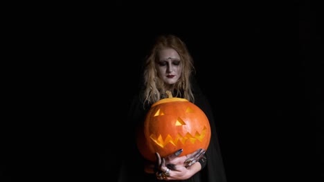 Halloween-Image-.Young-Witch-In-Black-Clothes-Holds-Pumpkin-In-Her-Hands.