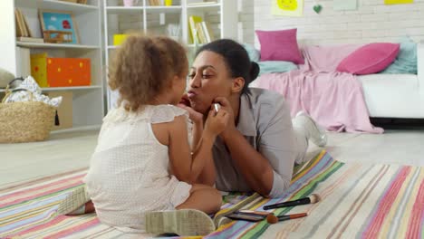 Chica-aplicando-maquillaje-en-la-cara-de-la-madre