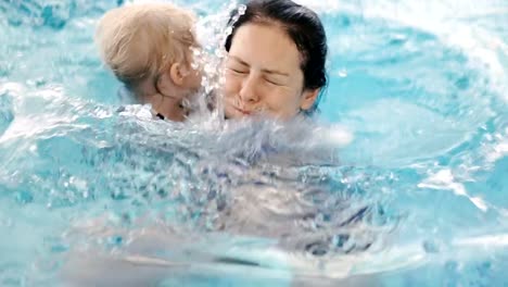 Videoclip.-Mama-lehrt-ein-Kind-im-Pool-zu-schwimmen.