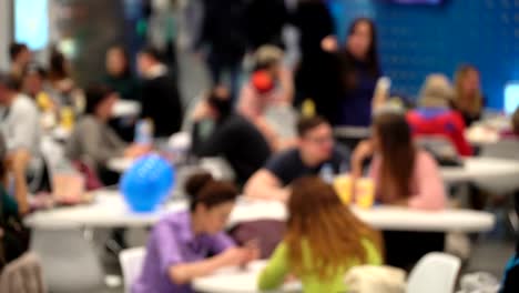 Alimento-de-la-chatarra-del-concepto.-Irreconocible-gente-comiendo-comida-rápida-en-patio-de-comidas-del-centro-comercial