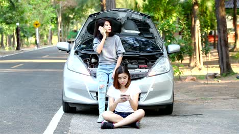 Two-woman-having-car-trouble-and-calling-technician