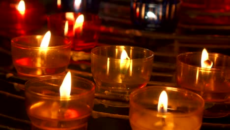 Candles-burning-in-catholic-church.-Festive-glow-in-cathedral.-Holy-place-illuminated-by-flames