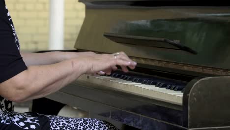 Old-woman-open-cover-and-start-playing-the-piano