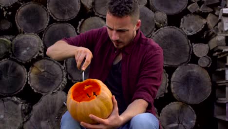 Hombre-talla-de-una-calabaza-hueca-en-el-patio-trasero-en-un-tocón-de-árbol