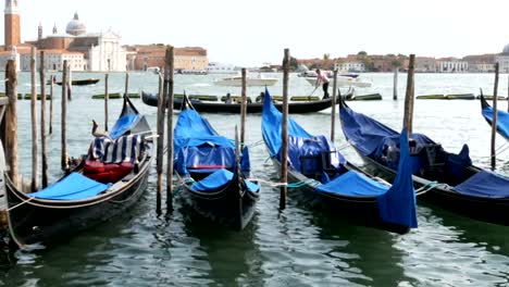 Schöne-schwarze-Gondeln-stehen-und-Schaukeln-auf-den-Wellen-des-Canal-Grande-in-Venedig