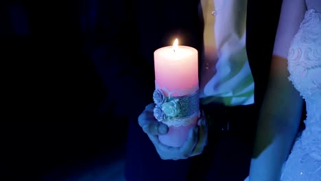 Burning-candle-in-the-hand-of-men-in-the-dark.-Slow-motion-shot