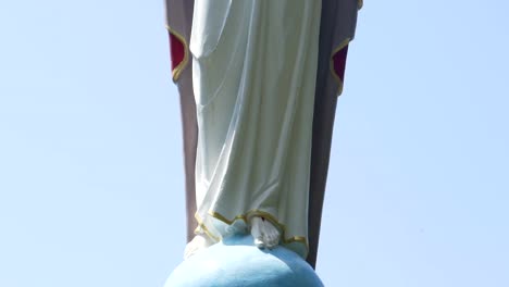 Escultura-de-Cristo-con-los-brazos-extendidos-contra-el-cielo,-panorama-vertical