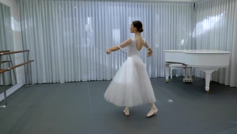 Ballerina-aus-weißem-Tutu-und-Pointe-Ballettschuhe-wirbelte-im-Ballettstudio
