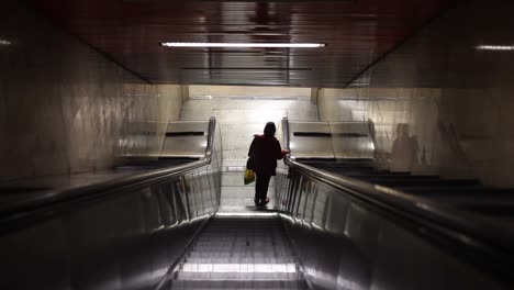 Frau-reitet-auf-Rolltreppe-im-Untergrund