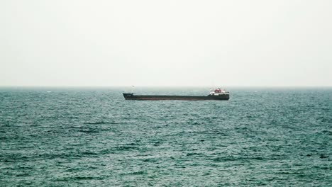 a-huge-dry-cargo-ship-is-anchored-next-to-the-horizon