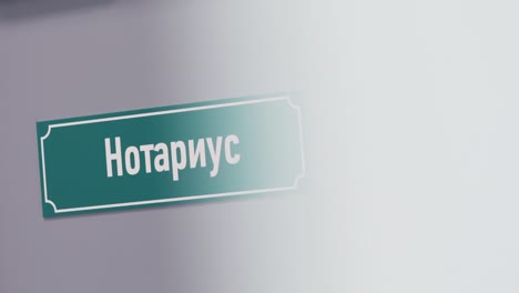 Green-plastic-sign-on-door-with-russian-text-sais-notary