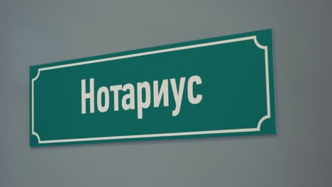 Green-plastic-sign-on-door-with-russian-text-sais-scrivener