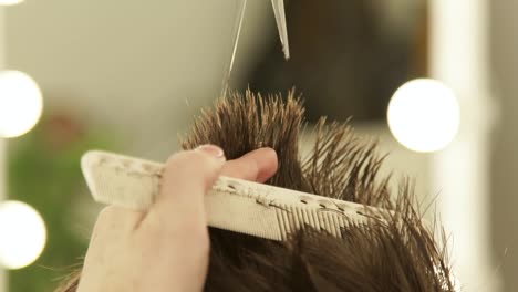 Manos-peluquería-corte-de-cabello-con-tijeras-y-peinado-de-cerca.-Haircutter-hacer-peinado-masculino-con-peine-y-tijeras-profesionales-en-salón-de-belleza