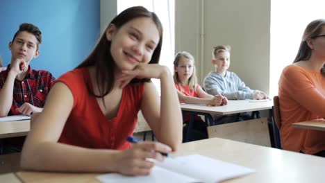 estudiantes-con-los-cuadernos-en-la-lección-en-la-escuela