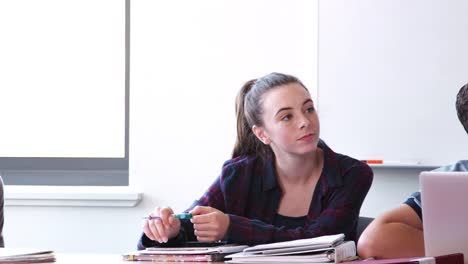 Alumnos-de-secundaria-con-dispositivos-digitales,-escuchar-al-maestro-en-clase-de-tecnología