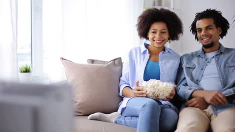 smiling-couple-with-popcorn-watching-tv-at-home