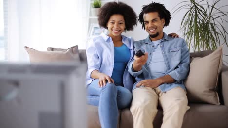 happy-smiling-couple-watching-tv-at-home