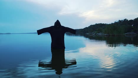 Evil-witch-in-black-cloak-with-hood-in-the-river.