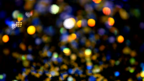 Defokussierten-schillernden-bunten-Glitter-Konfetti,-schwarzer-Hintergrund.-Urlaub-abstrakte-festliche-Bokeh-Lichtpunkte.