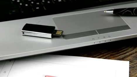 Schieberegler-erschossen.-Arbeitsplatz-mit-Laptop,-USB-Stick-und-Stift,-stehend-auf-einem-Schreibtisch-aus-Holz