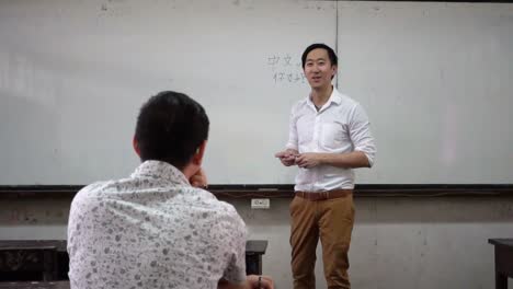 Junge-asiatische-orientalische-Fremdsprache-Lehrer-geben-ein-Sprachkurs-im-Klassenzimmer