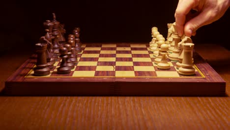 chess-player-making-a-move-in-the-game-on-wooden-table