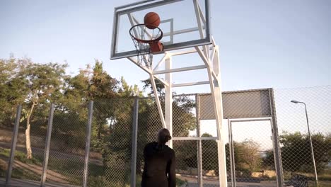 Tomas-de-ángulo-bajo-de-un-jugador-de-baloncesto-femenino-profesional-en-acción.-Chica-practicando-al-aire-libre-en-la-cancha,-lanzar-una-pelota-a-la-red.-Vista-de-parte-trasera