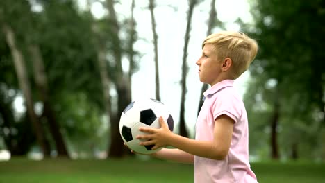 Boy-playing-football-with-father-in-park,-outdoor-weekend,-active-lifestyle