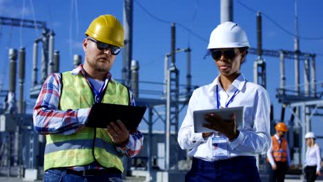 Two-electrical-workers-on-tablets-outside