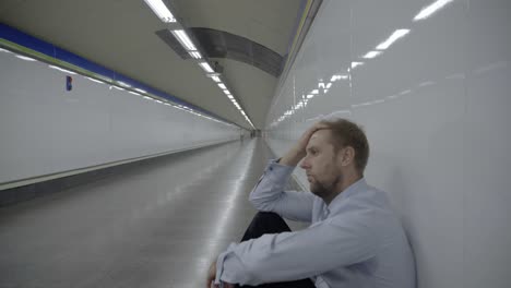 Verzweifelte-traurige-Jungunternehmer-emotionalen-Schmerz-Trauer-und-Tiefe-Depression-allein-sitzen-in-Tunnel-u-Bahn-Stress-Lebensstil-Arbeit-Probleme-scheitern-Arbeitslosigkeit-psychische-Gesundheit-und-Depressionen-leiden.