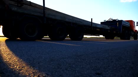 Camera-follow-to-truck-driving-along-highway-in-countryside.-Lorry-rides-through-the-rural-with-beautiful-landscape-at-background.View-on-the-country-highway.-Slow-motion