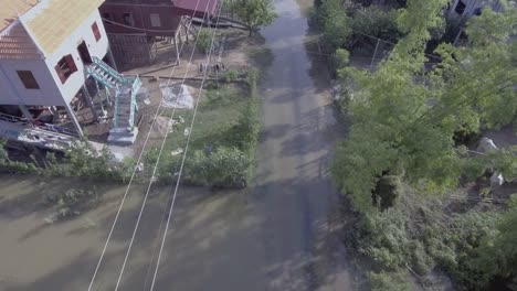 Aerial-vertical-shot-looking-down-over-a-flooded-street-village-in-rural-area