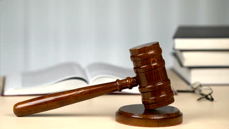 Judge-workplace-in-courtroom,-gavel-and-law-books-on-desk-before-proceeding