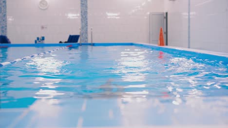 Schwimmkurse-für-Kinder-in-den-Pool---schönes-hellhäutige-Mädchen-im-Wasser-schwimmt