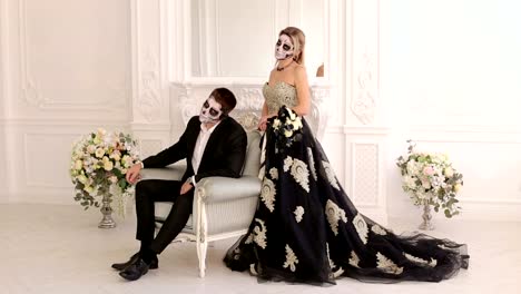 Pareja-espeluznante-con-el-maquillaje-de-Halloween-de-miedo-en-trajes-vintage-en-un-estudio.