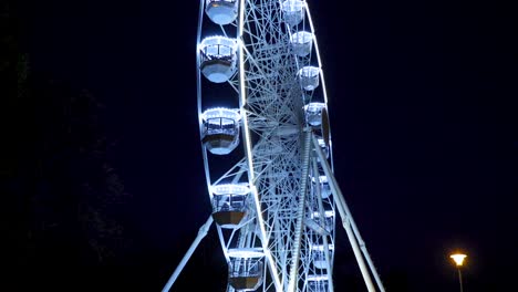 Movimiento-grande-rueda-de-Ferris-en-Brno,-República-Checa-en-Moravske-Plaza-de-lado-durante-la-instalación-para-el-evento-de-Navidad-capturado-en-la-noche