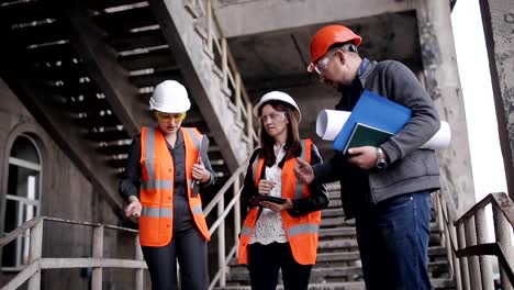 Die-Vorarbeiter-und-zwei-Frauen-Inspektoren-um-den-Arbeitsplan-zu-diskutieren-auf-Bau-oder-die-Restaurierung-des-Gebäudes-durchgeführt.