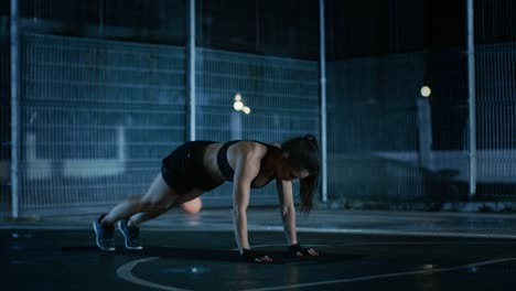 Schöne-sportliche-Fitness-Girl-Doing-Push-Up-Übungen.-Sie-ist-ein-Training-in-einem-eingezäunten-Basketballfeld-im-freien-tun.-Nacht-Aufnahmen-nach-Regen-in-einer-Wohngegend.