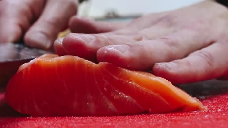 Chef-takes-out-bones-from-the-salmon-fillet,-cutting-fish-on-slices-for-cooking-sushi-in-4k-resolution-in-slow-motion