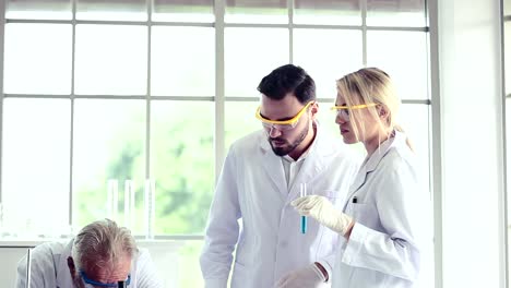 Science-teacher-and-students-team-working-with-chemicals-in-lab