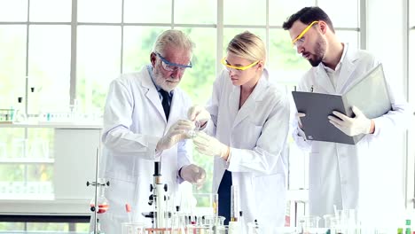 Science-teacher-and-students-team-working-with-chemicals-in-lab