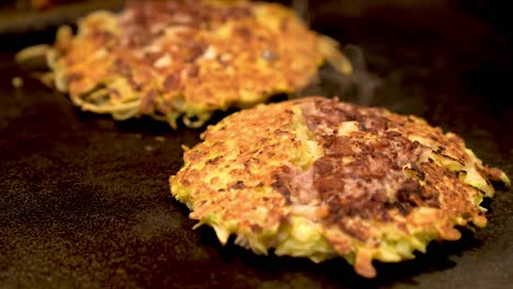 Okonomiyaki-auf-der-heißen-Eisenplatte-gekocht-wird