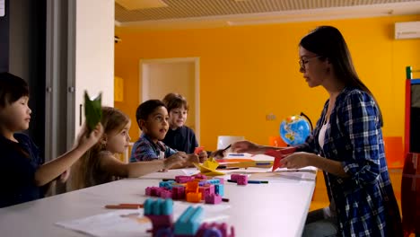 Teacher-and-kids-making-origami-ship-in-art-class